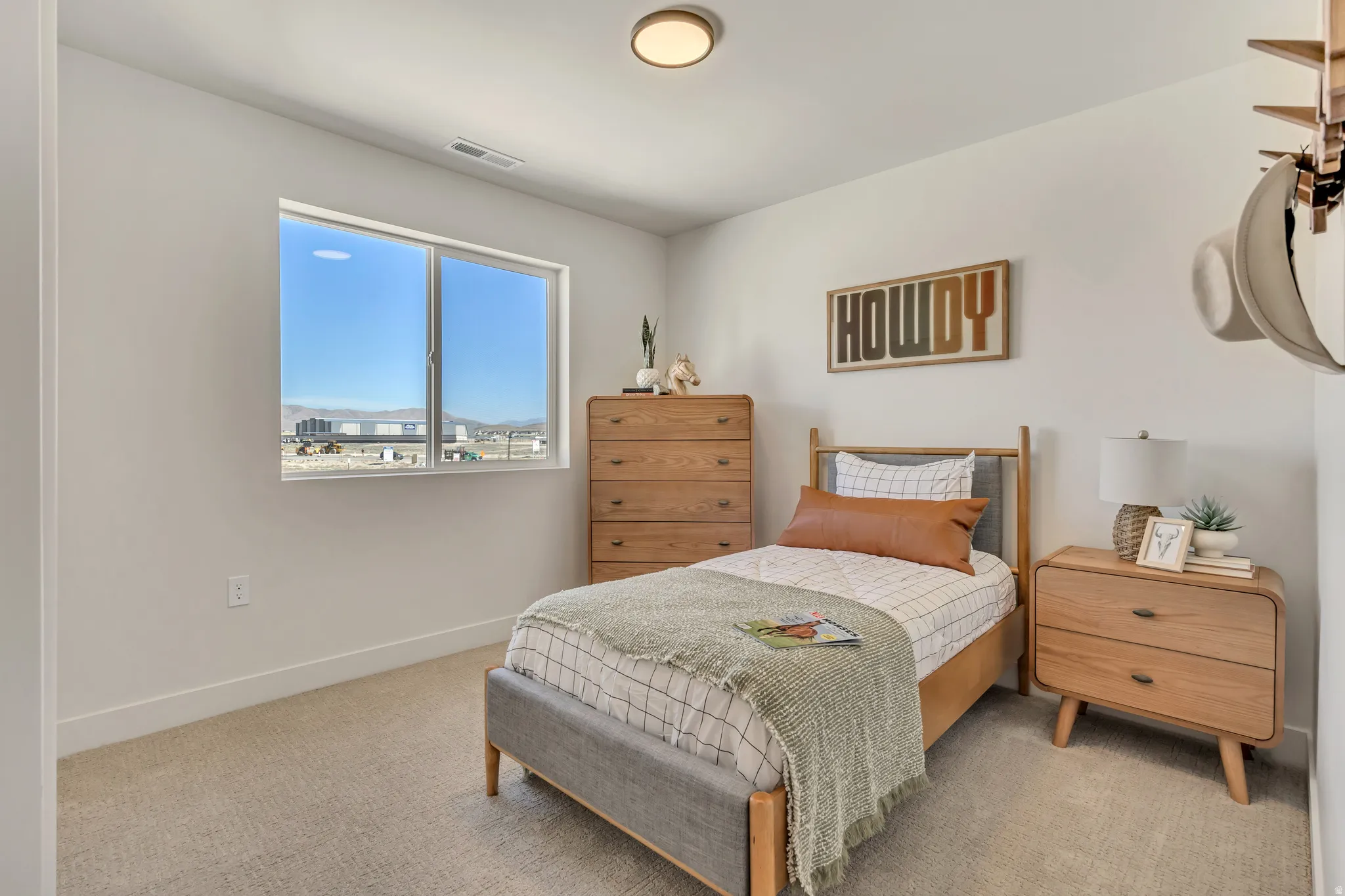 Bright room with a large window, neutral carpet, and a flush-mount ceiling light