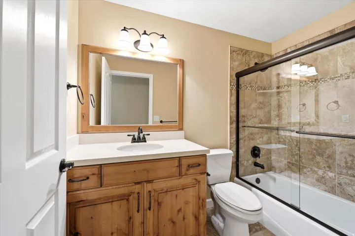 Bathroom vanity with a wood-finish cabinet, light countertop, and an undermount sink