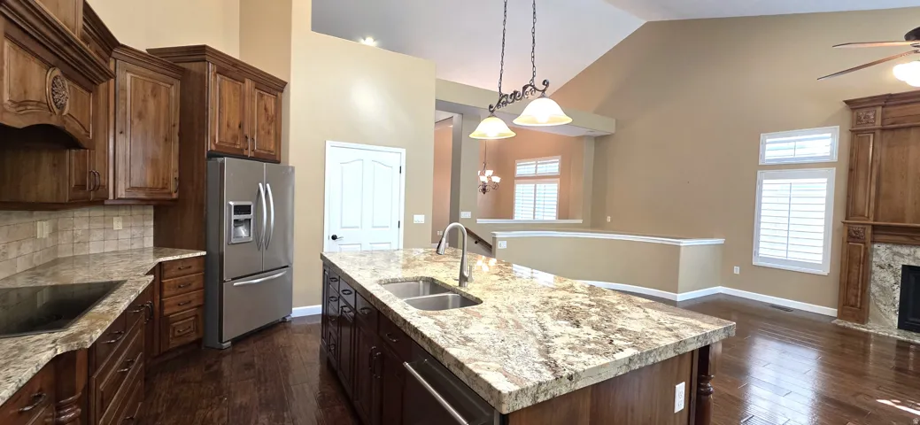 Kitchen featuring wood cabinetry, stainless steel appliances, and a central island with an integrated double sink