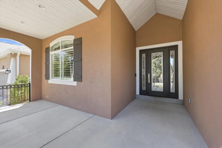 Welcome porch featuring an arched entryway and a decorative glass entry door with sidelights