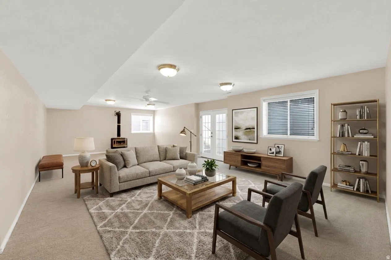 Spacious living area featuring neutral carpeting, a built-in wood-burning stove, and ample natural light from multiple windows