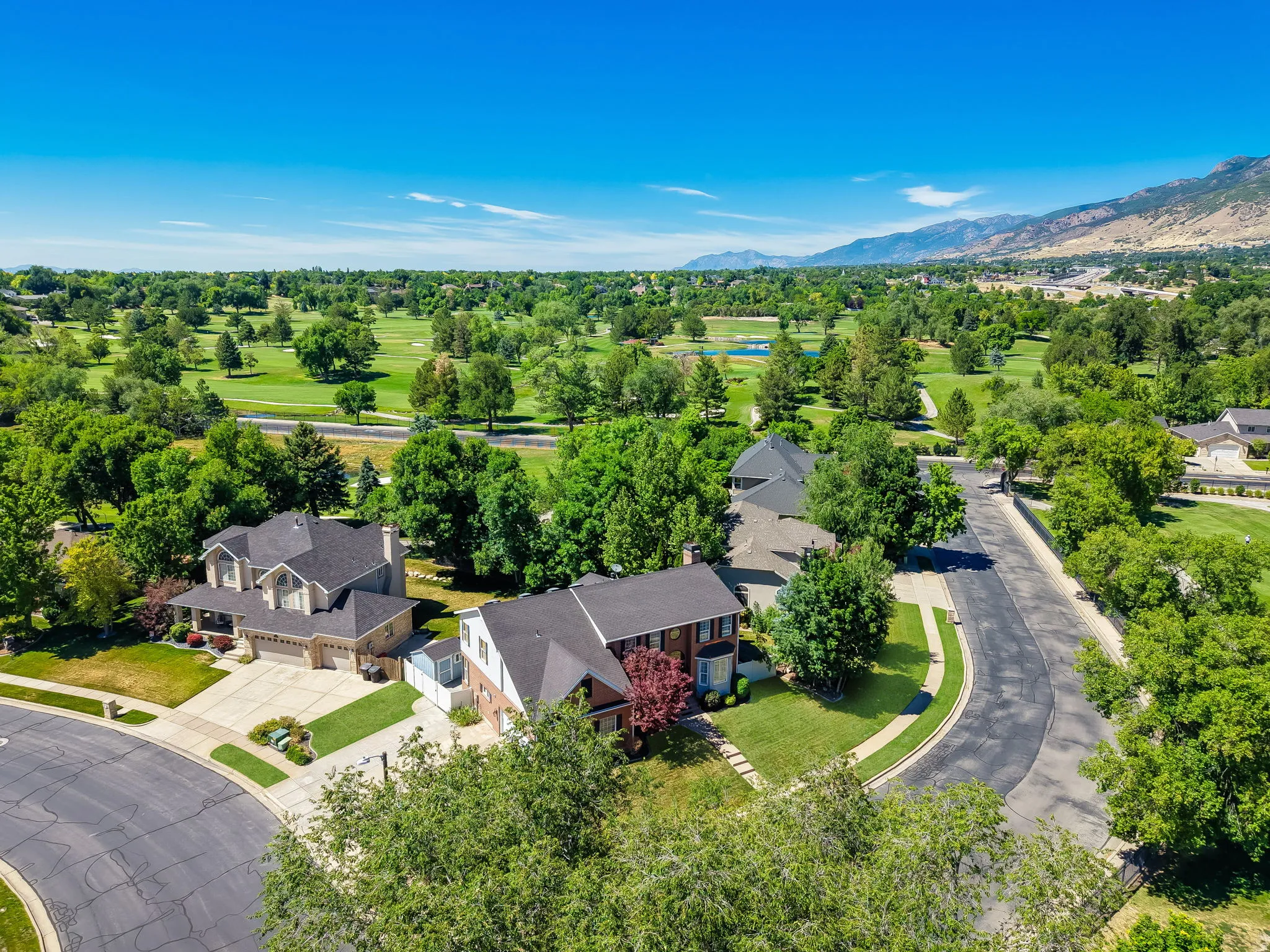 Expansive neighborhood featuring mature trees and a manicured golf course backdrop