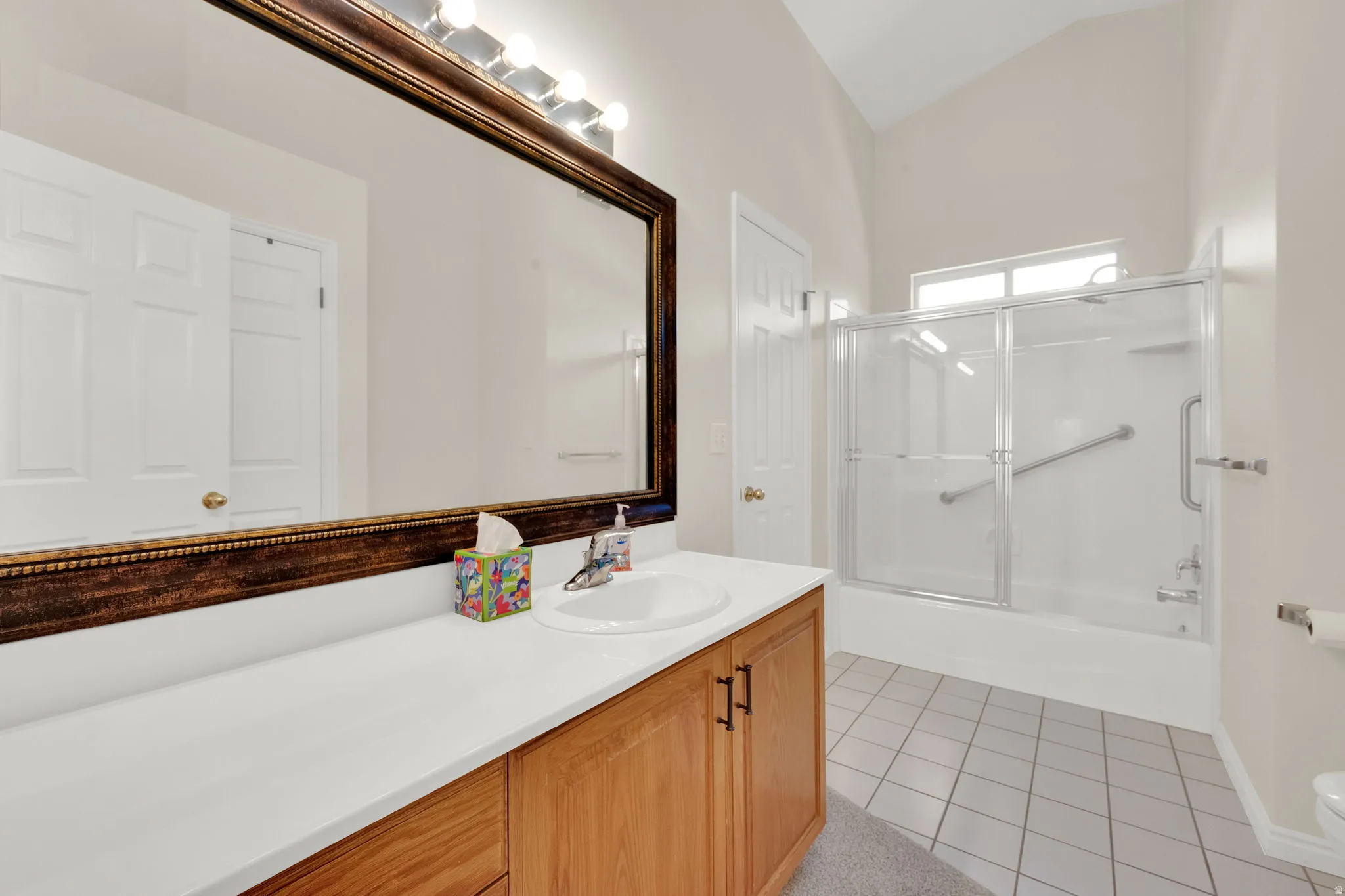 Bathroom featuring a single vanity with wood-finish cabinetry, a white countertop, and an integrated sink