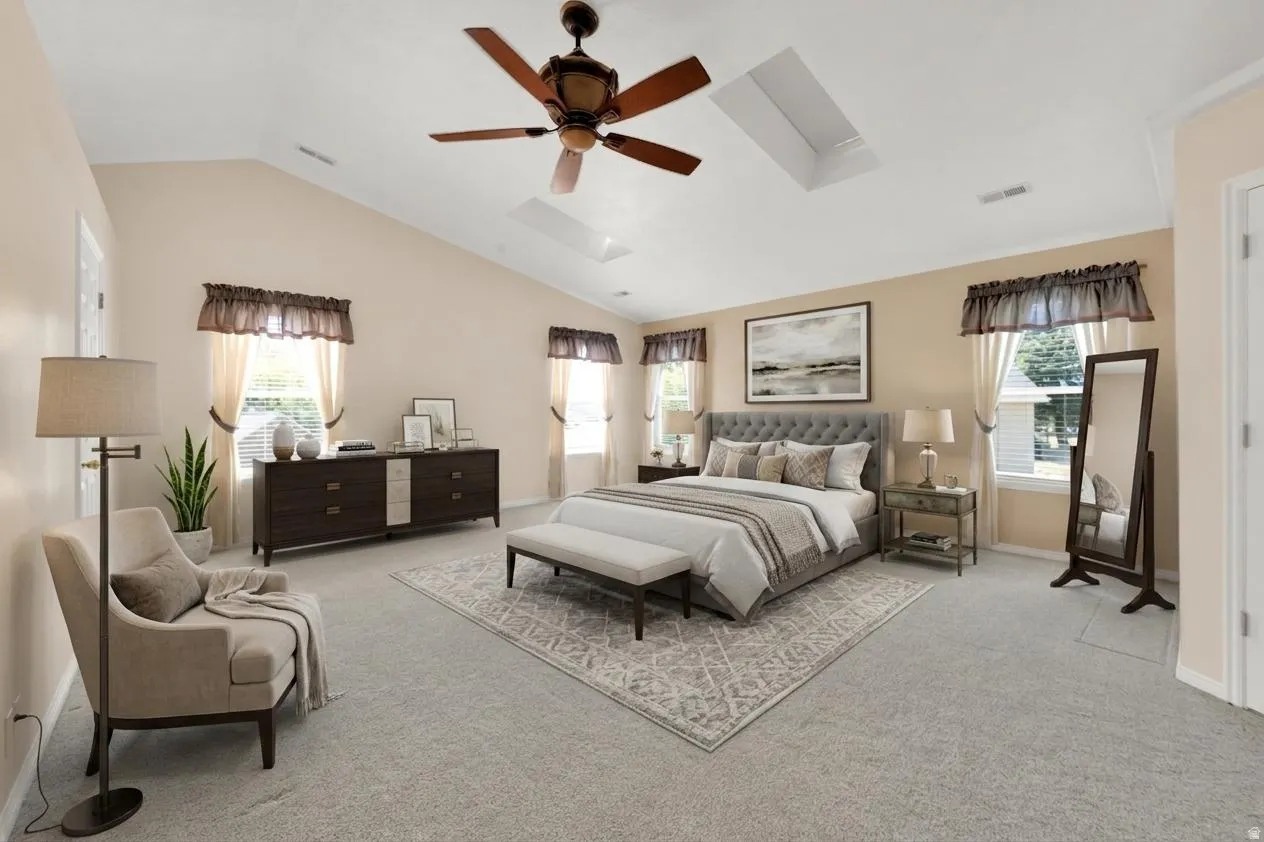 Vaulted ceiling featuring a ceiling fan and two skylights