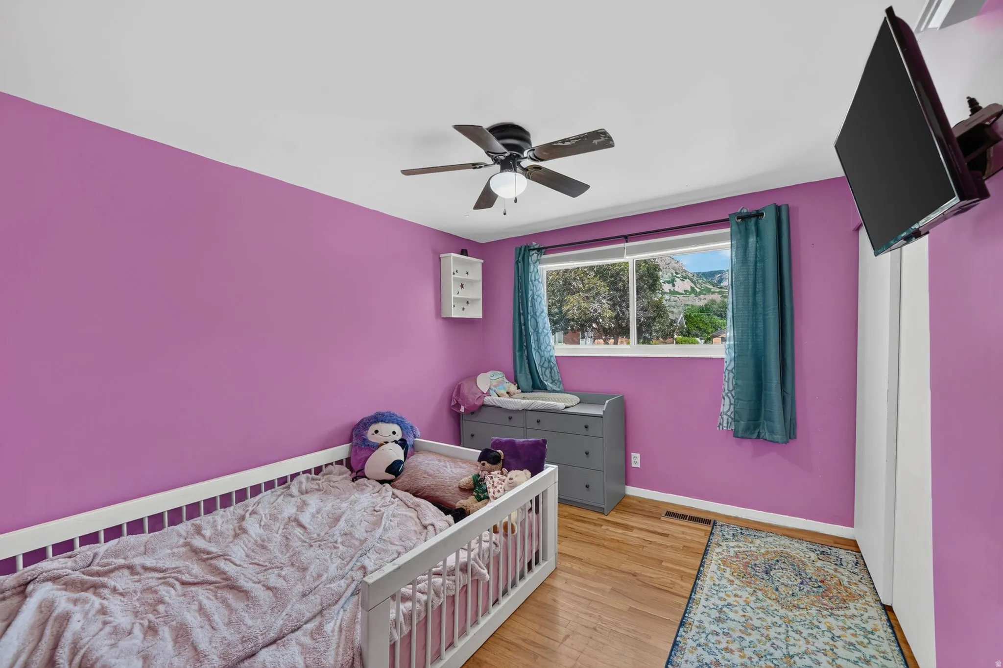 Room featuring wood-finish flooring and a ceiling fan