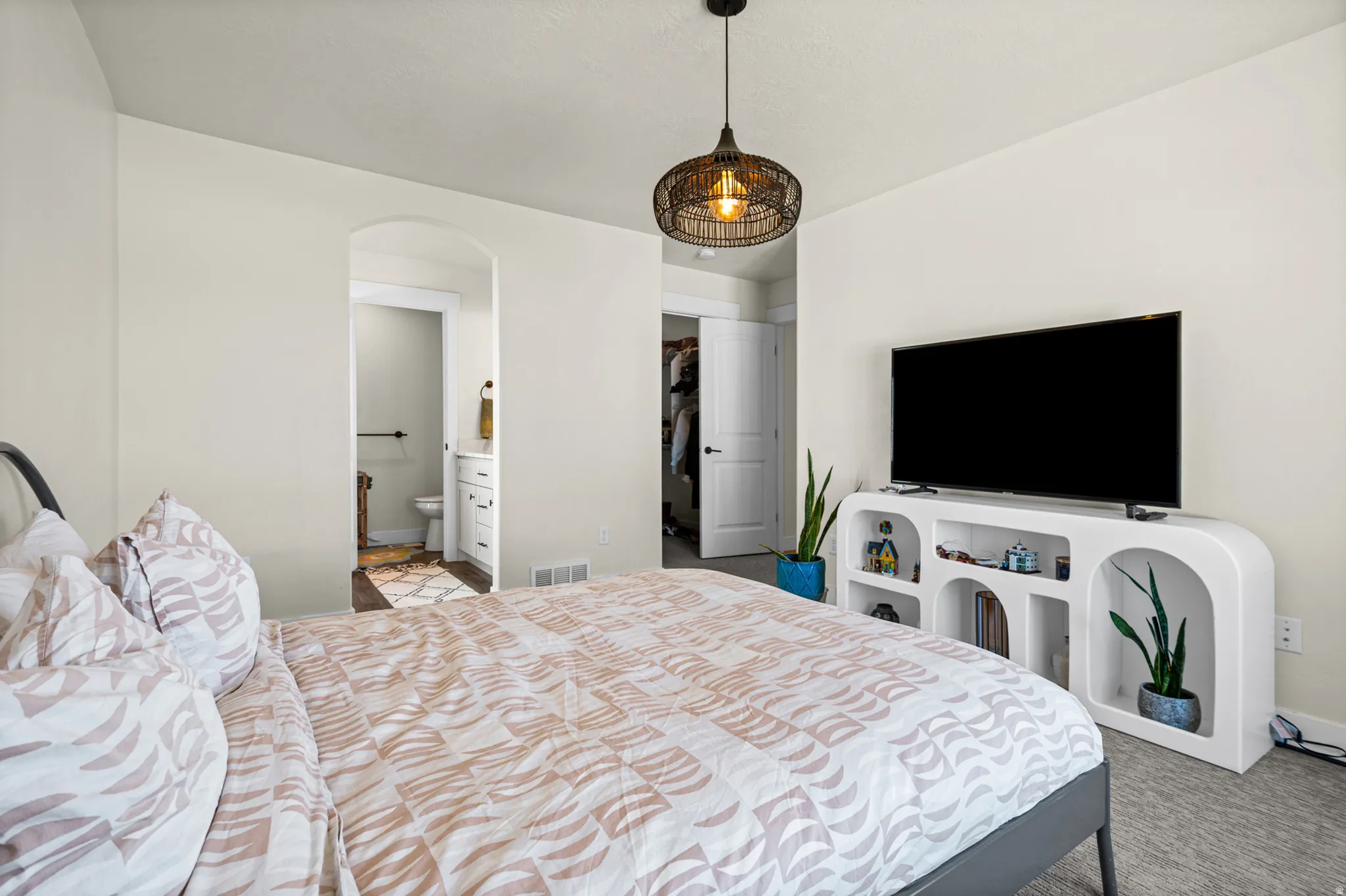 Spacious room featuring neutral tone walls, recessed lighting, and a contemporary pendant light fixture