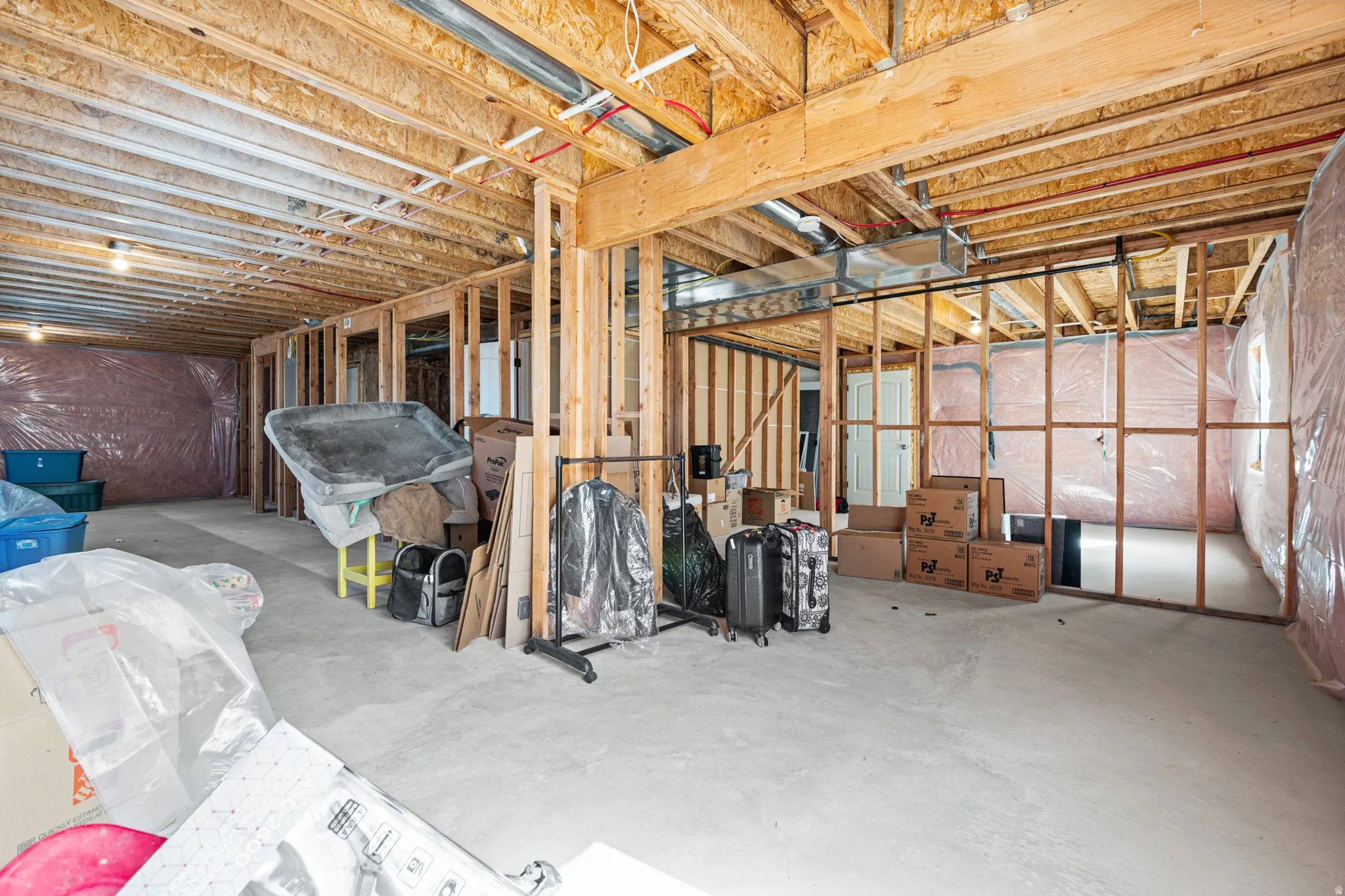 Unfinished basement offering substantial future potential, featuring exposed wood framing, concrete flooring, visible HVAC ductwork, and ceiling joists
