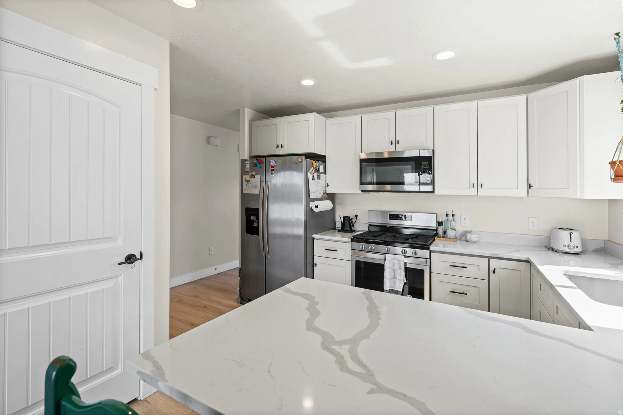 Modern kitchen with white cabinetry and stainless steel appliances