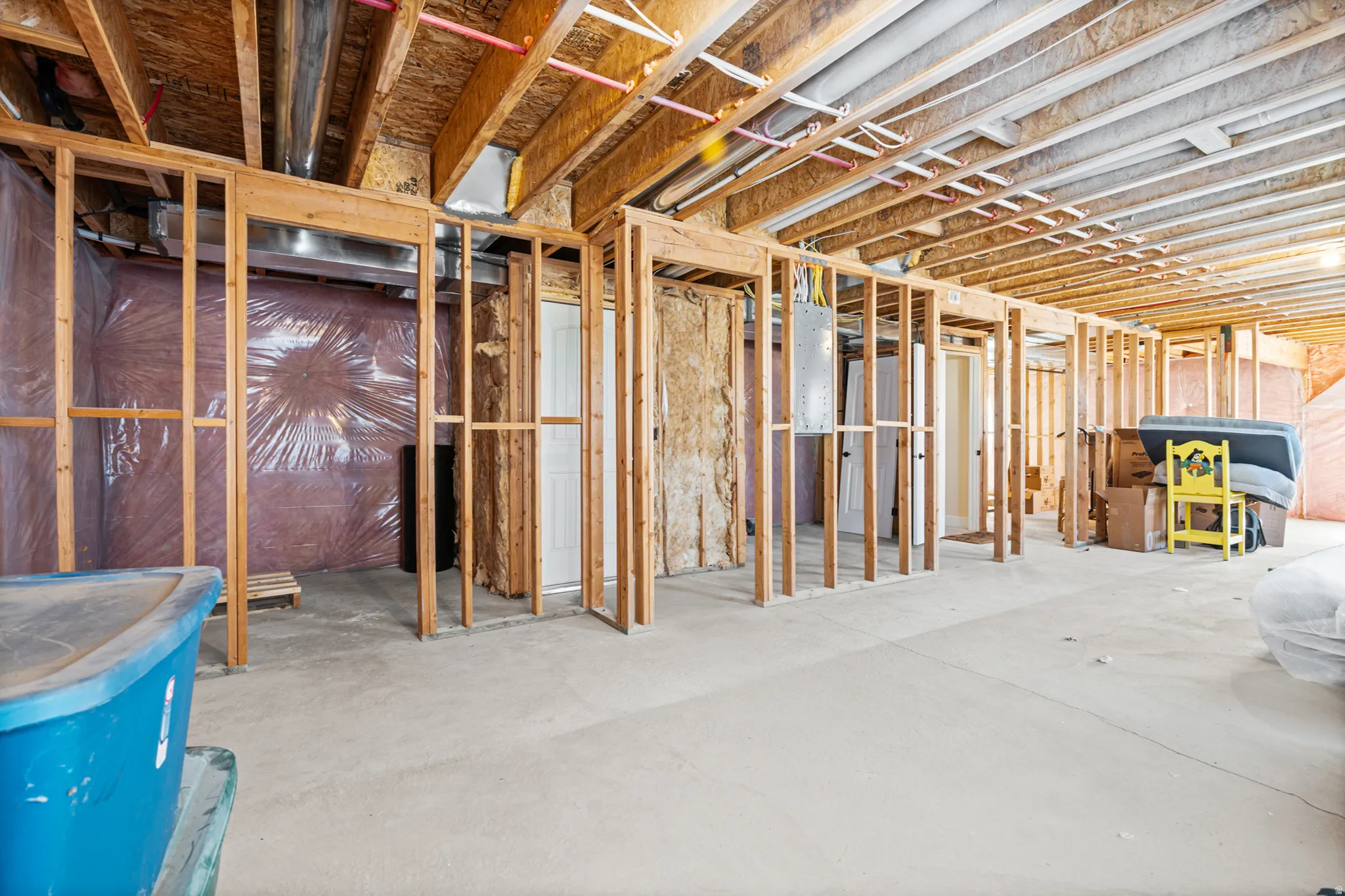 Unfinished basement space featuring exposed wooden joists and framing