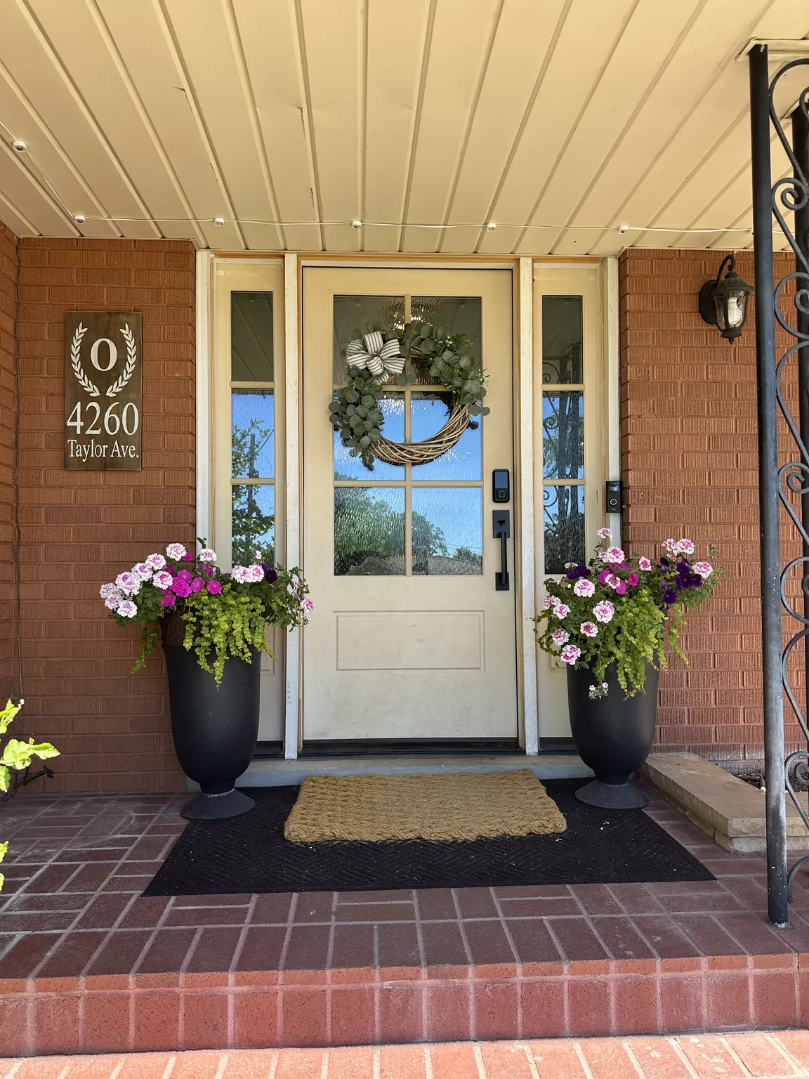 Brick facade with a covered porch featuring a cream-colored entry door with sidelights!