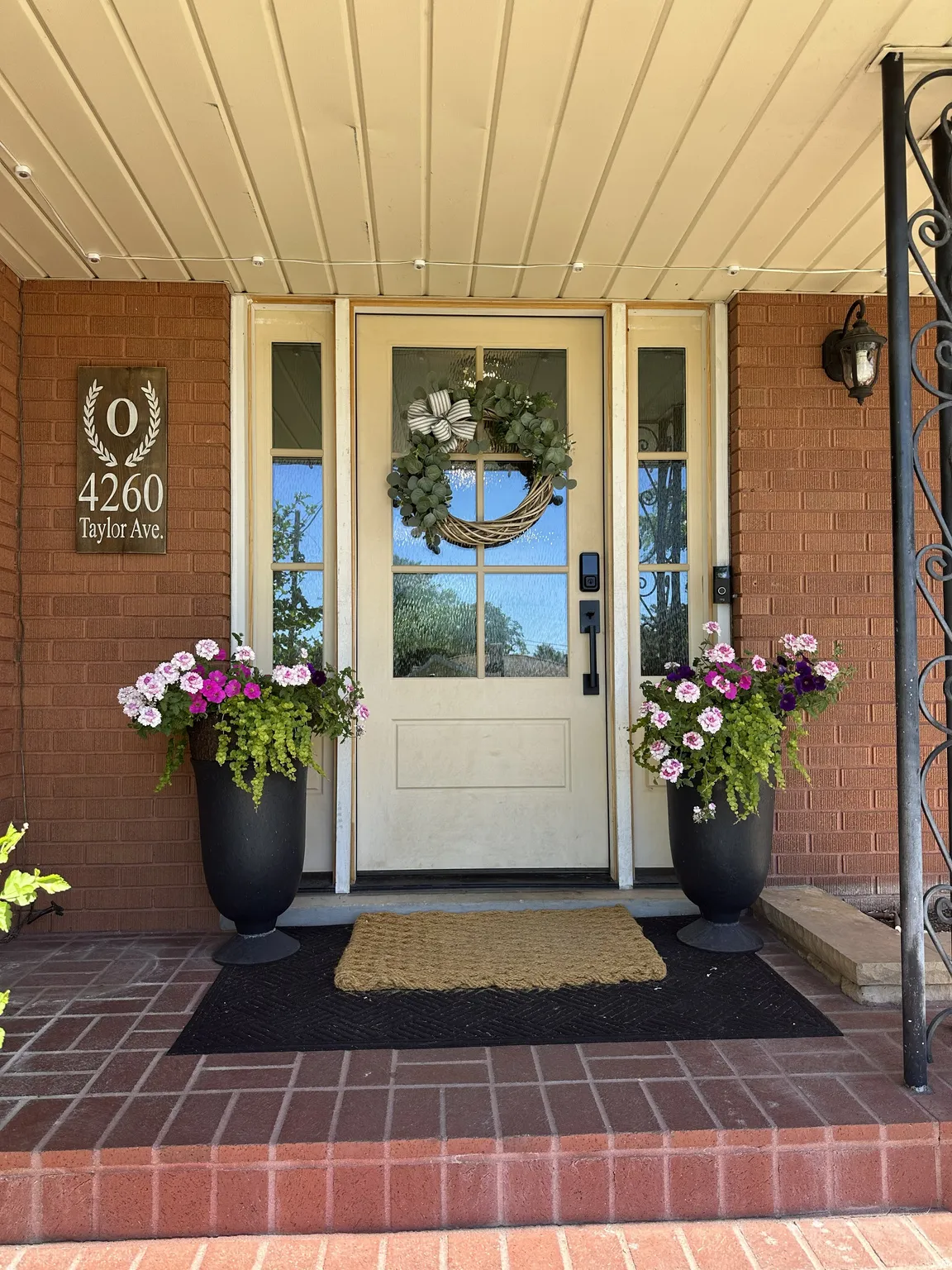 Brick exterior entrance featuring a light-colored glass-paneled door, sidelight windows, and a brick porch!