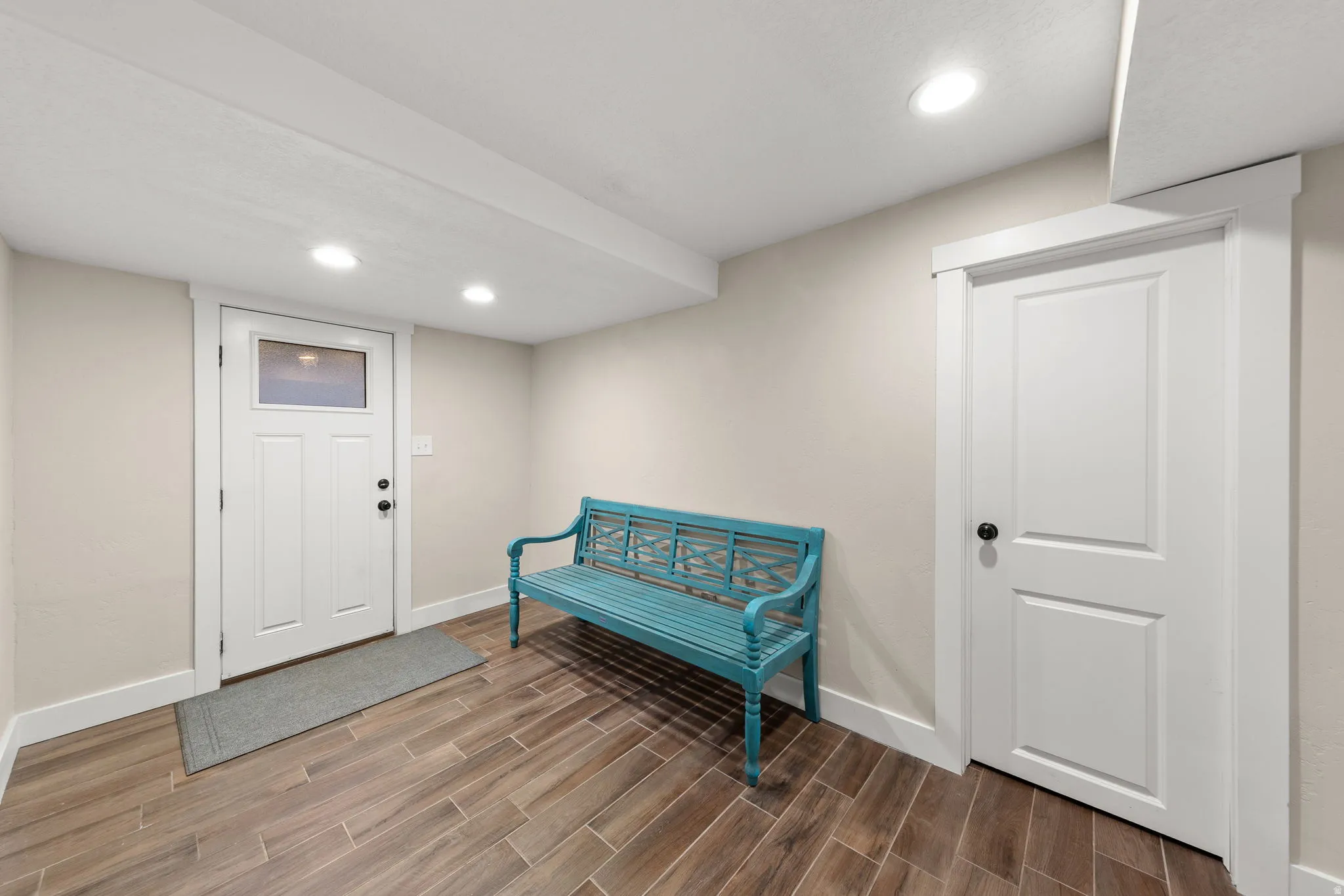 Entryway featuring wood-finish tile flooring, recessed lighting, and a white paneled door with a frosted transom window!