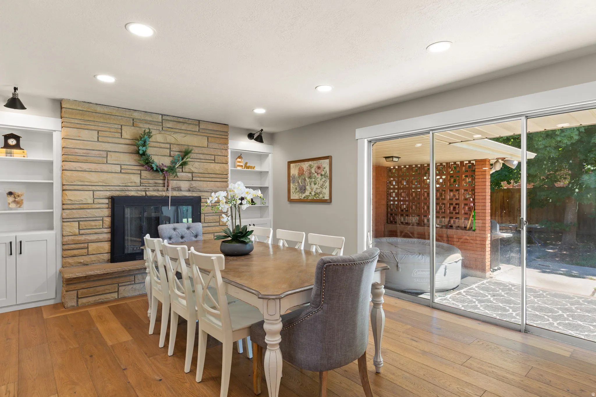 Serene & invigorating dining area with fireplace next to sliding glass door that opens to a beautiful green backyard!