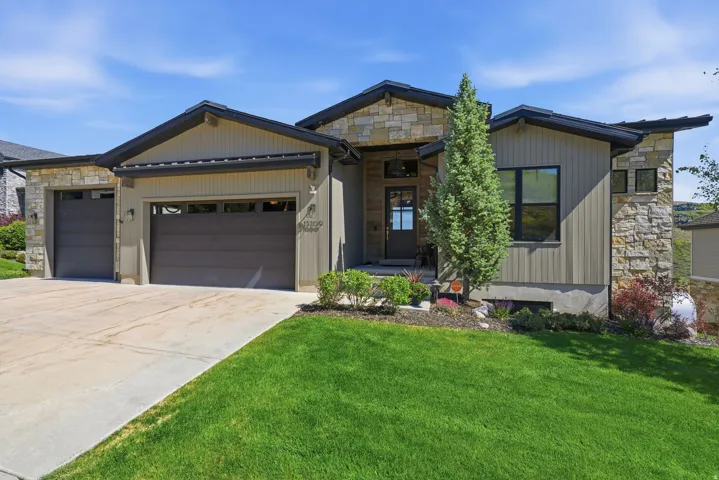 Contemporary exterior featuring stone veneer and vertical siding accents