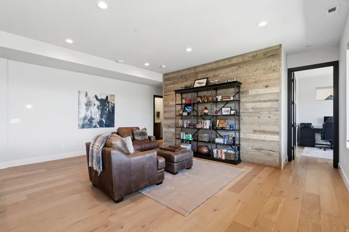 Open concept interior featuring light wood-finish flooring, a wood plank accent wall, and recessed lighting