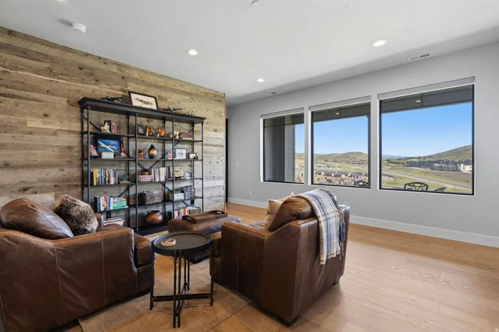 Living area featuring a reclaimed wood accent wall, recessed lighting, and light wood-finish flooring