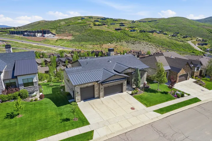 Modern residence featuring a stone and stucco exterior with a dark metal roof