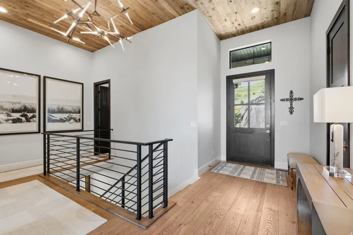 Vaulted wood-paneled ceiling with a contemporary chandelier
