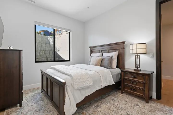 Recessed lighting and a singular window with roller shade