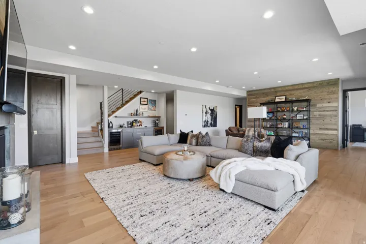 Spacious living area featuring light wood-finish flooring and recessed lighting