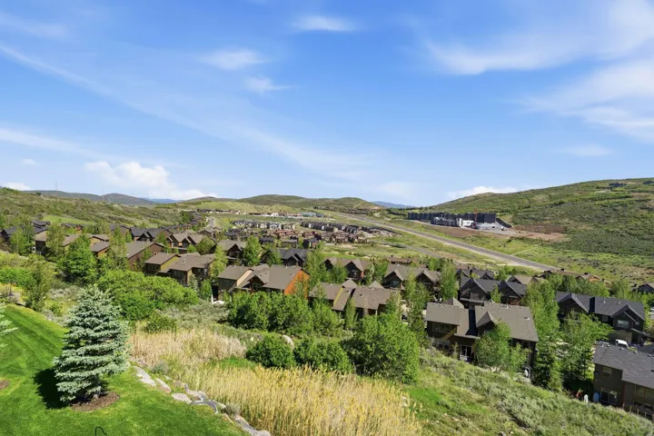 Expansive hillside community featuring numerous homes with dark roofs and mature landscaping