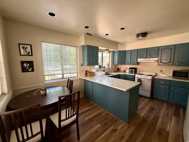 Kitchen featuring wood-finish flooring, recessed lighting, and a window with blinds