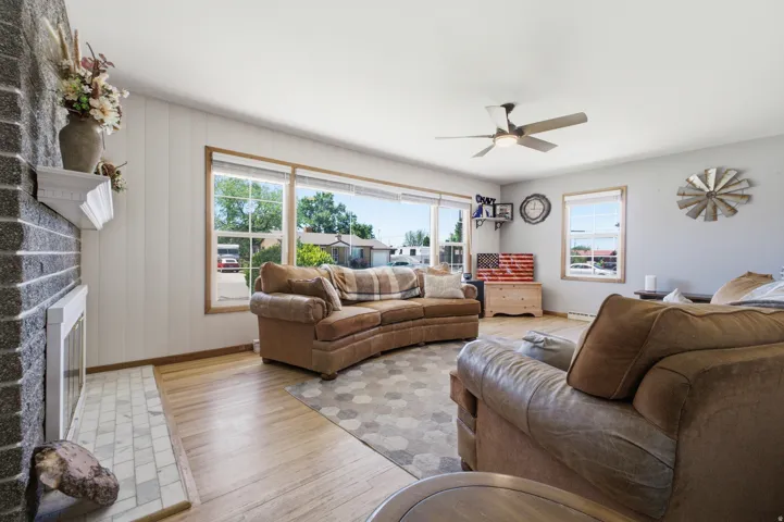 Spacious living area featuring a prominent fireplace with a gray stone surround and white mantel
