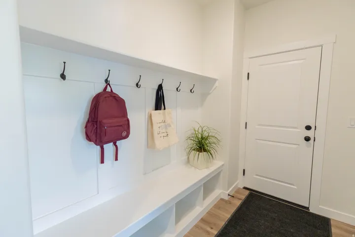 Built-in mudroom bench with cubby storage, featuring a shiplap-style back panel and dark-finish coat hooks