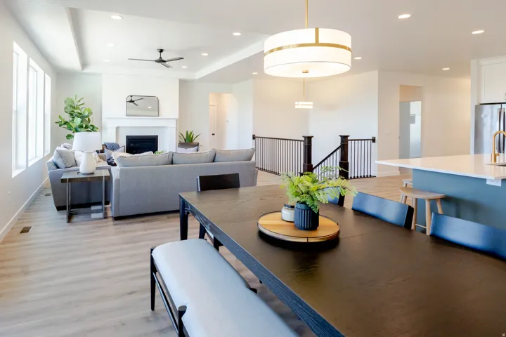 Open-concept living space featuring wood-finish flooring, a contemporary fireplace, tray ceiling, and recessed lighting