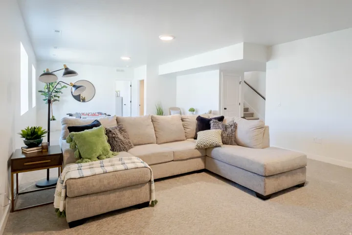 Open-concept living area featuring light neutral carpeting, recessed lighting, and white walls