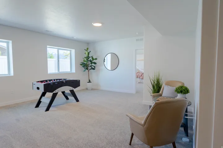 Spacious room featuring light-toned carpeting and white walls