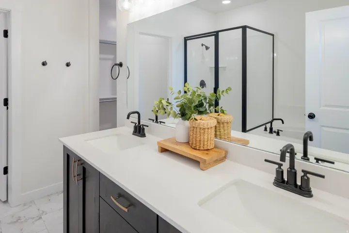 Dual vanity with white undermount sinks, matte black faucets, and a white countertop