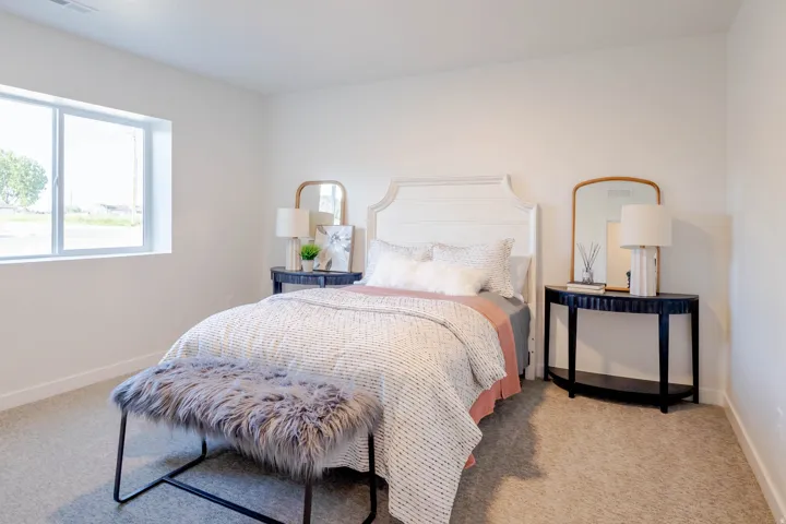 Bedroom featuring light neutral wall paint, a rectangular window, and carpet flooring