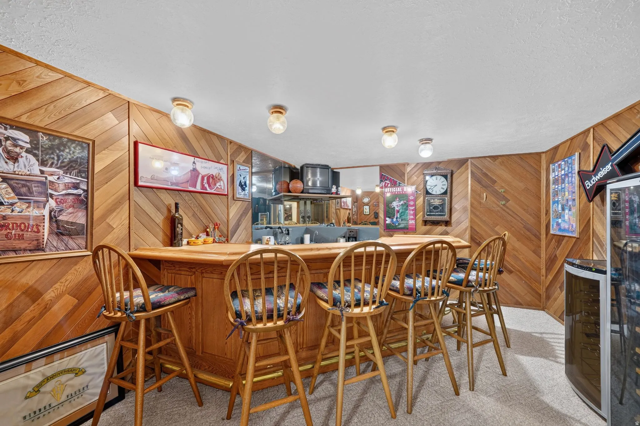 Built-in wooden bar with seating for four, featuring a wood-finish countertop and paneled walls