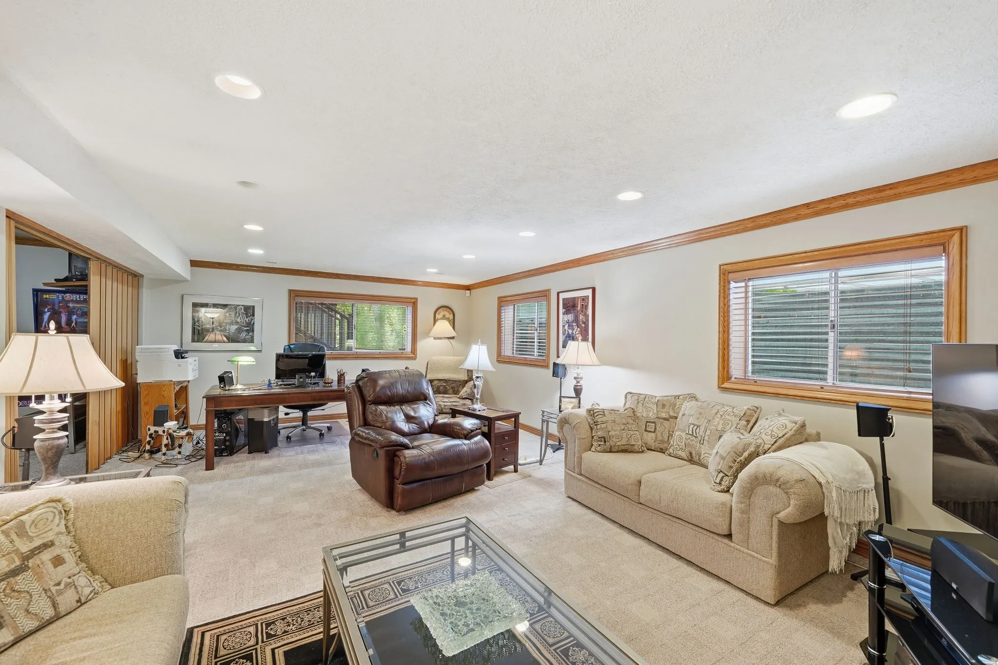 Carpeted room featuring recessed lighting, a built-in desk area, wood-trim windows, and crown molding