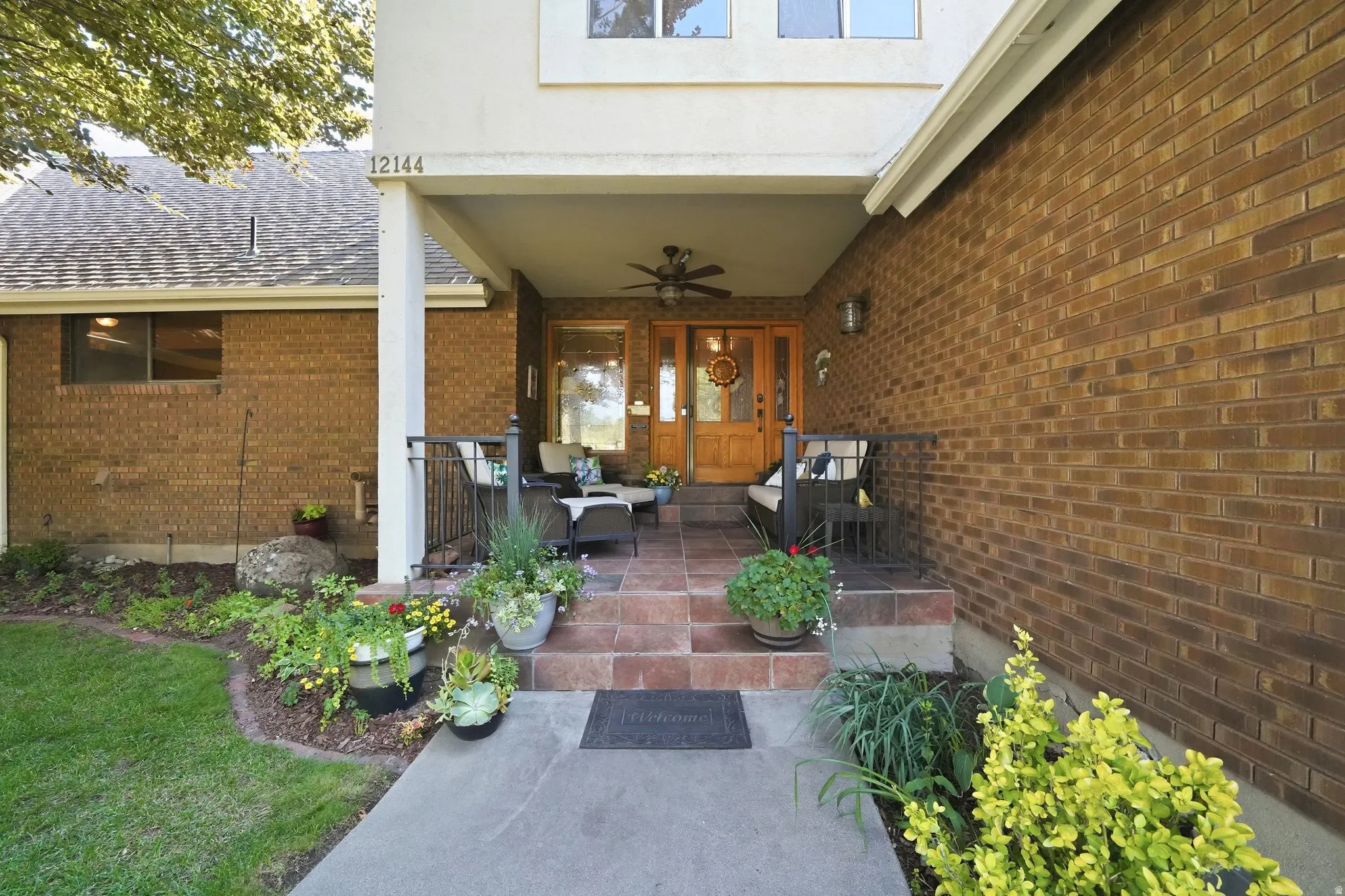 Brick exterior featuring a covered porch with a ceiling fan