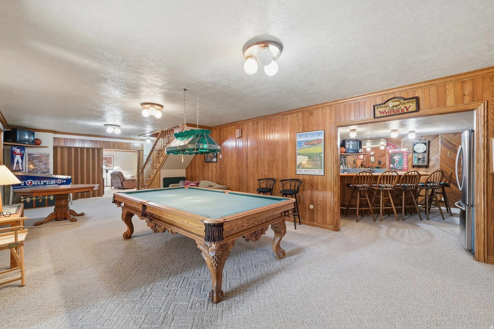 Entertainment area featuring light-toned carpeting and wood-paneled walls