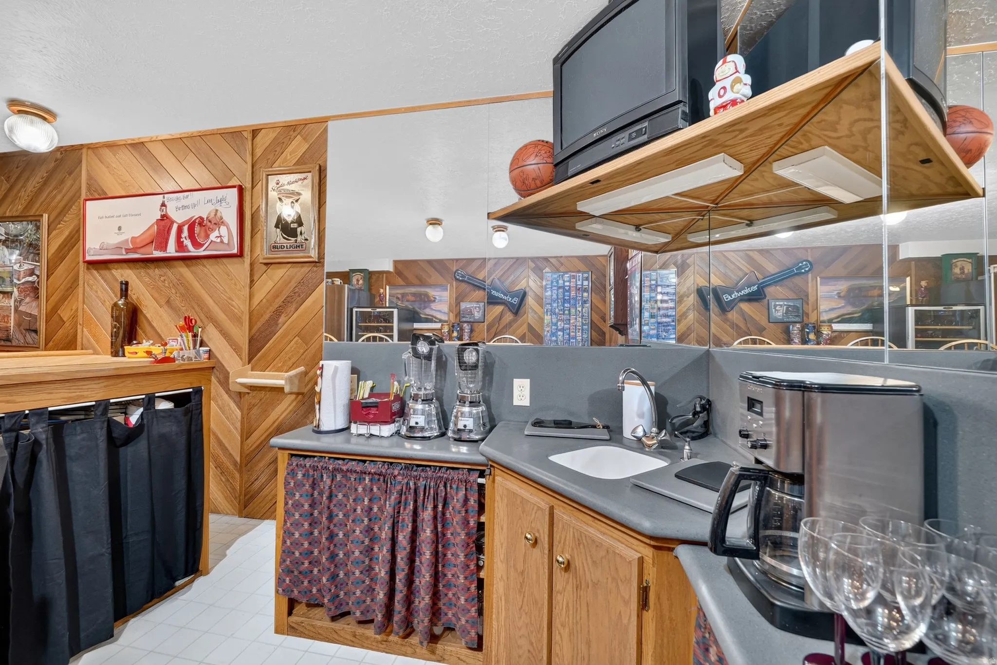 Built-in bar area featuring chevron wood-paneling, a light wood counter, and overhead lighting