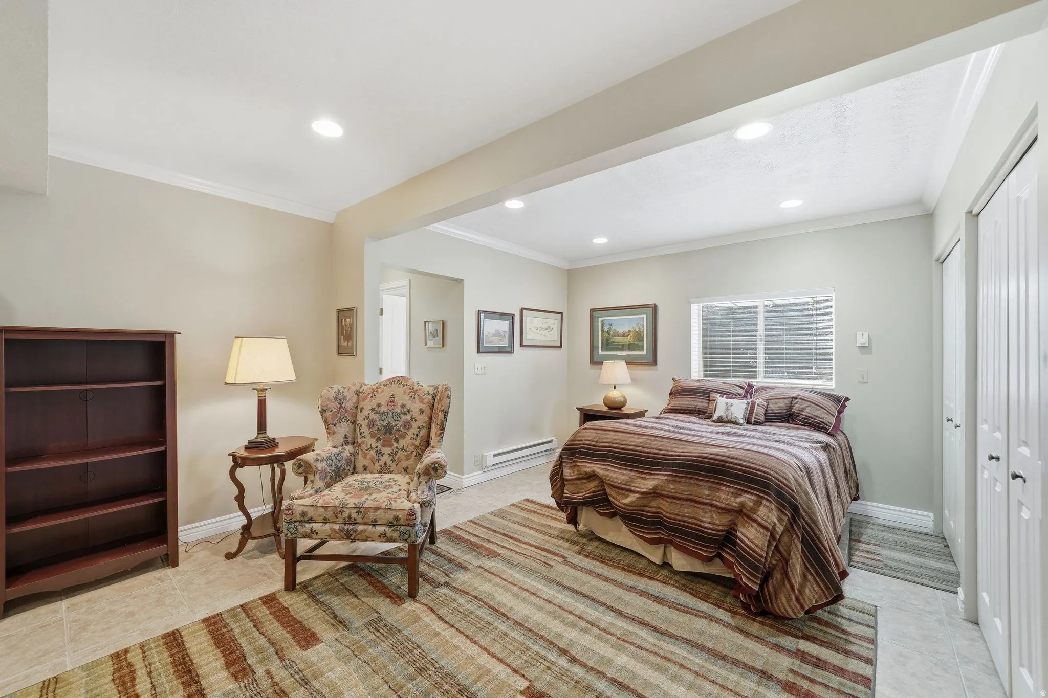 Spacious room featuring neutral paint, crown molding, recessed lighting, and tile flooring