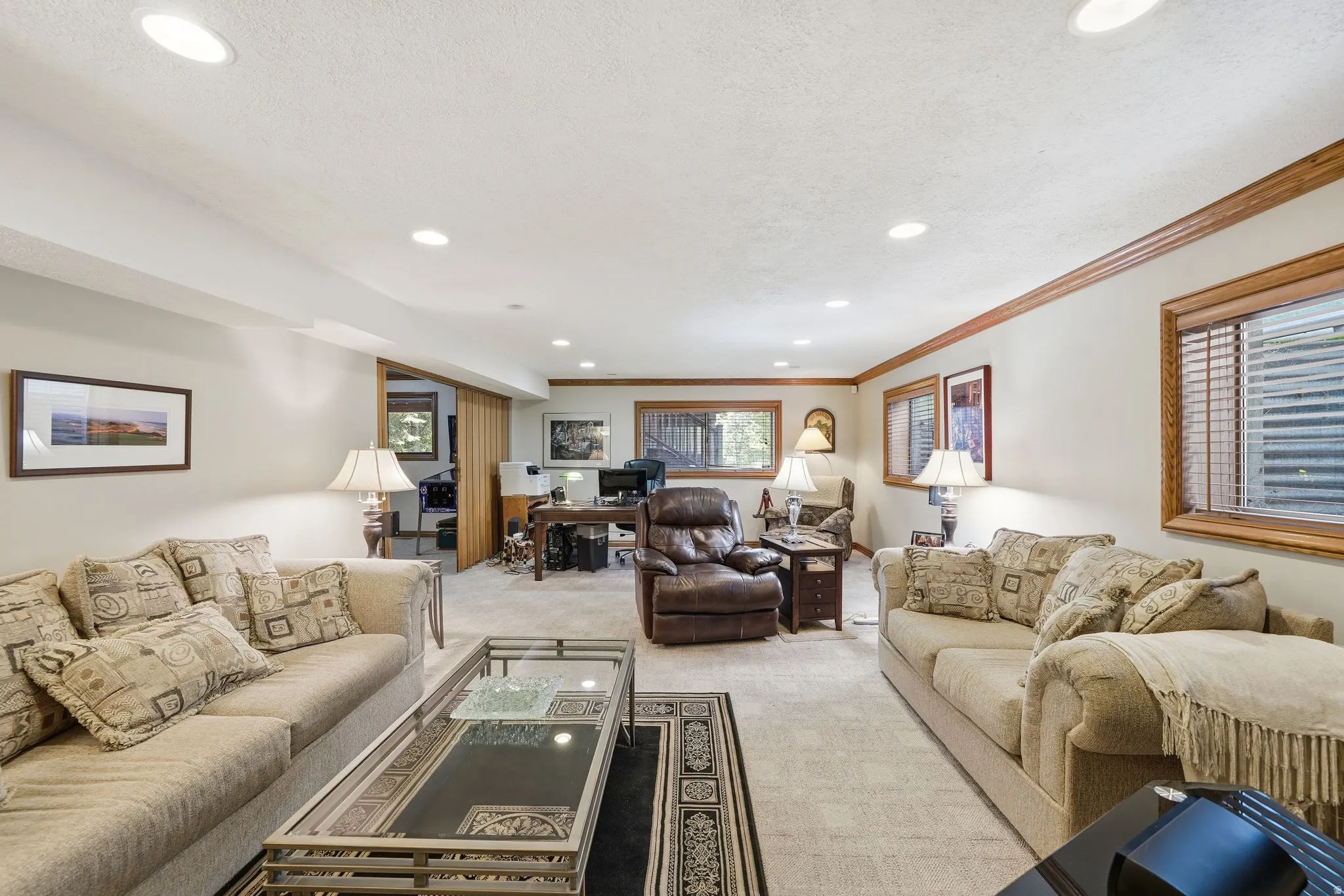 Carpeted living area featuring recessed lighting and wood-trim windows