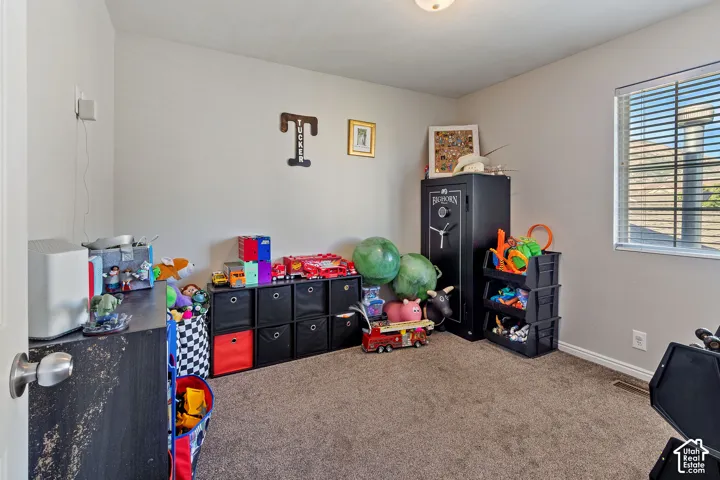 Carpeted interior room with neutral wall tones and a single window with blinds