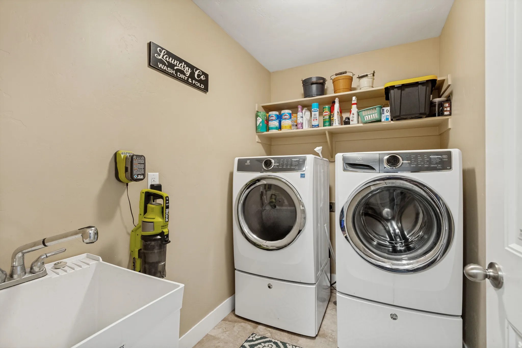 Main floor laundry with sink and tile floor