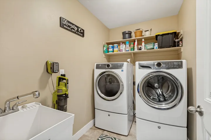 Main floor laundry with sink and tile floor