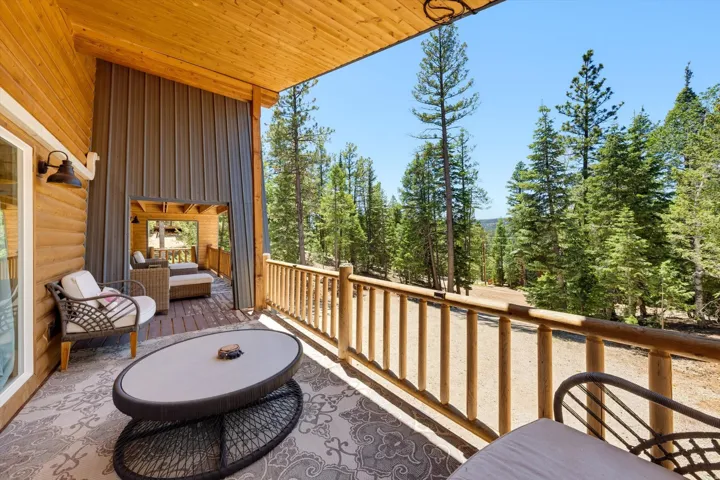 Expansive outdoor deck featuring wood-finish siding, a natural wood railing, and a tongue-and-groove ceiling