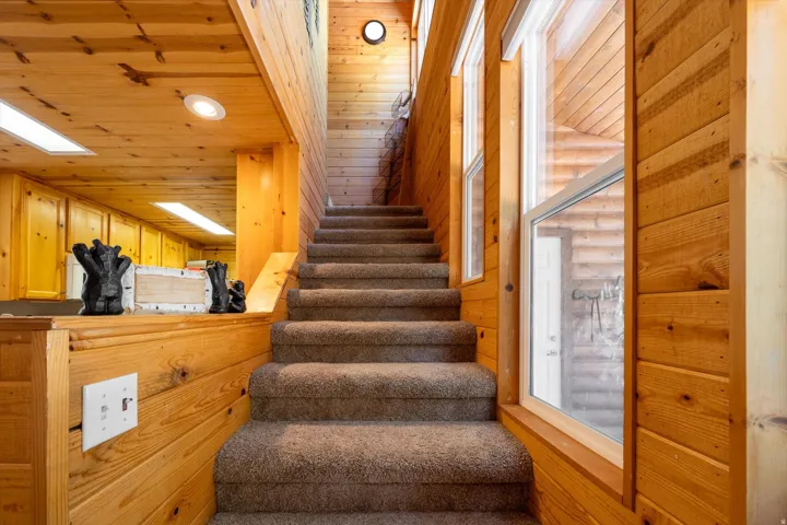 Interior staircase with carpeted treads and wood-finish walls