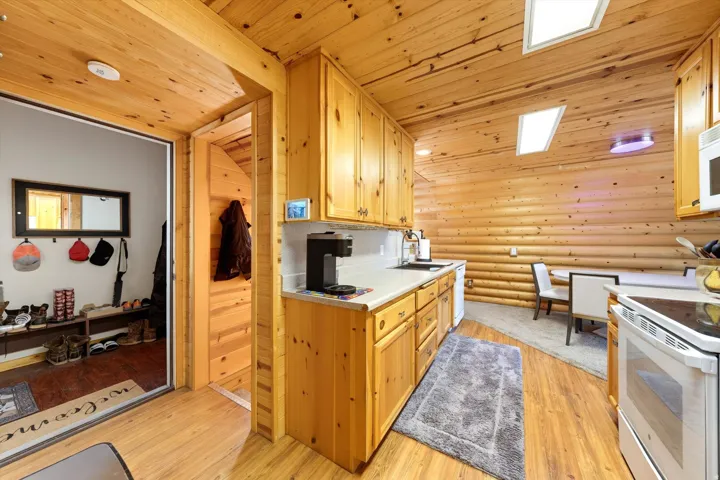 Kitchen featuring natural wood cabinetry, wood-finish flooring, and light countertops