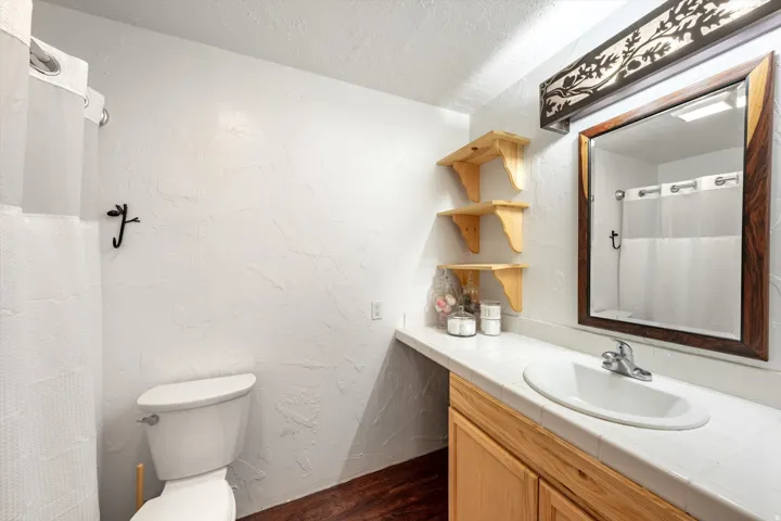 Bathroom featuring a built-in vanity with an integrated sink, wood-finish cabinetry, and a framed mirror