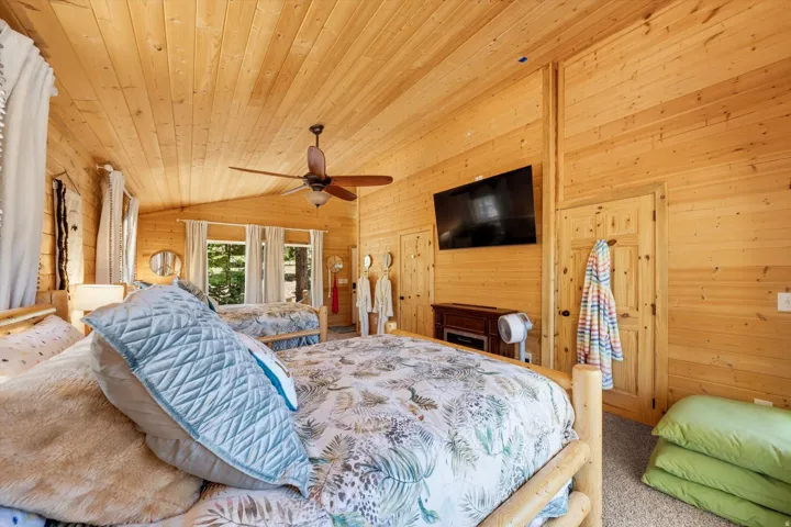 Interior room featuring wood plank walls and ceiling, a ceiling fan, and multiple windows