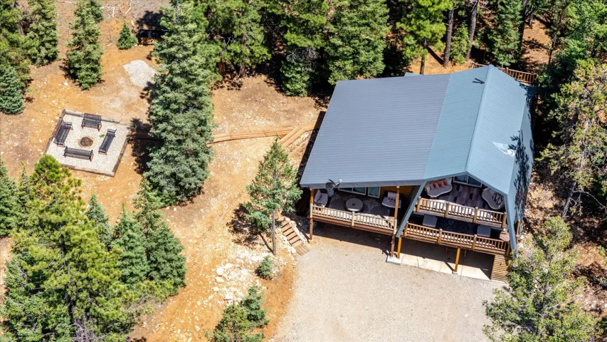 Wood-sided home featuring a gray metal roof and two levels of outdoor decking
