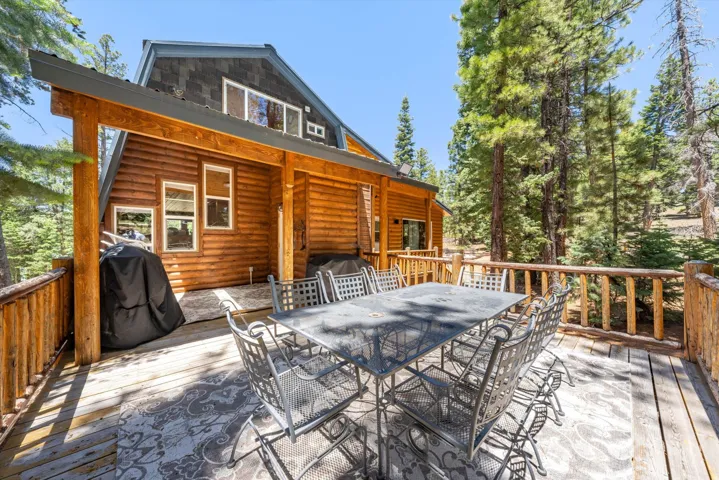 Expansive outdoor deck featuring wood-finish flooring and a log railing system